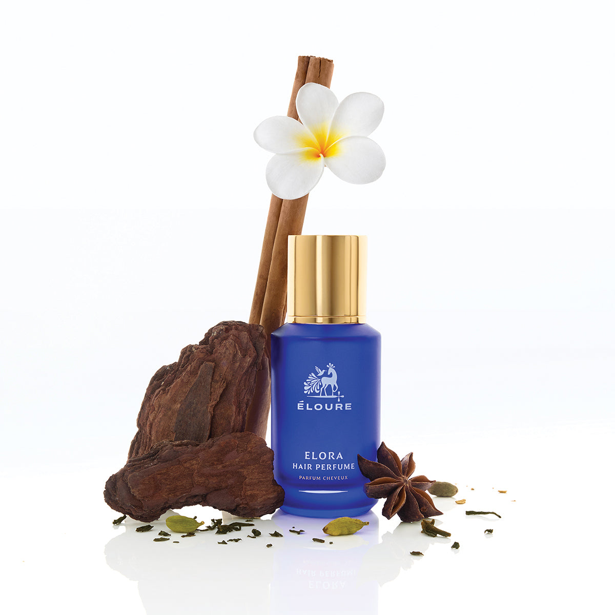 Éloure Elora Hair Perfume bottle staged with frangipani, cinnamon, sandalwood, cardamom and star anise