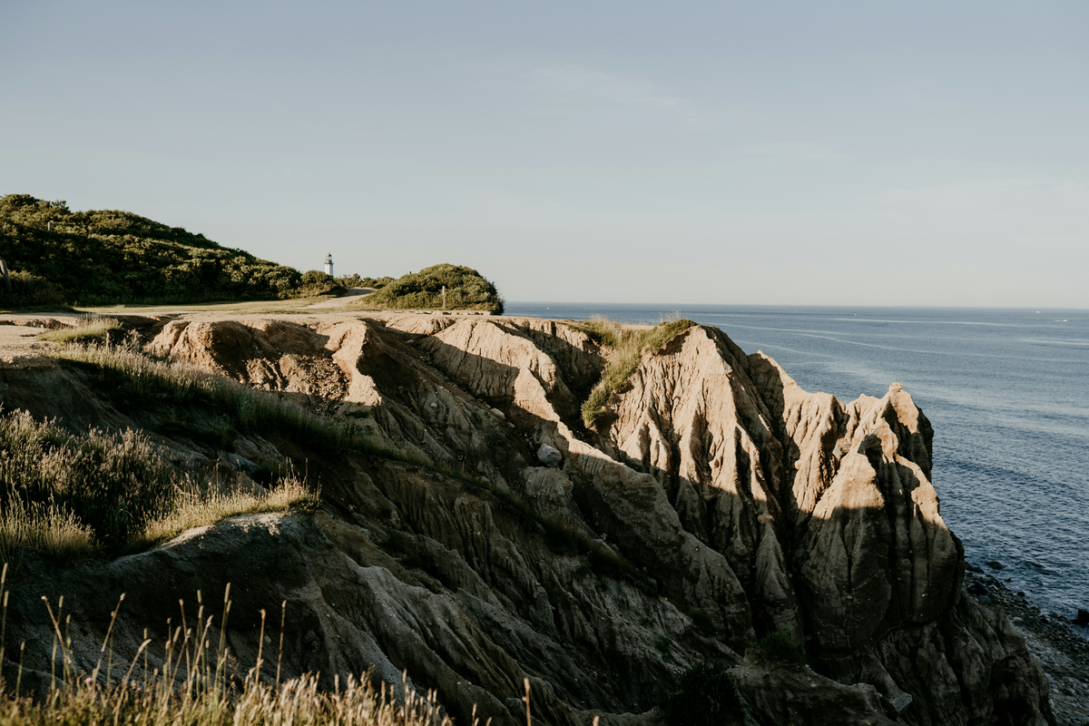 Coastal cliffs and lighthouse at golden hour
